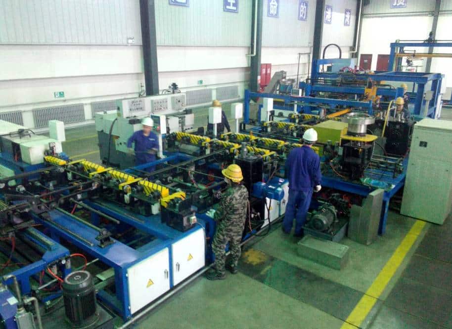  an industrial factory setting where workers in protective gear are operating and monitoring complex automated machinery