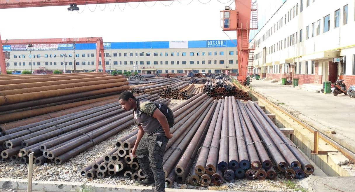 A CAMAL employee, , carefully checks a batch of steel at a supplier’s factory in China. They look at the surface, size, and strength to make sure it meets high-quality standards.