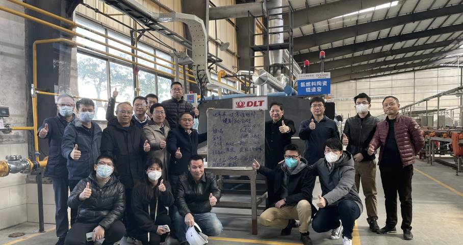 photo of KEDA employees placed around a sign with Chinese writing people have thumbs up