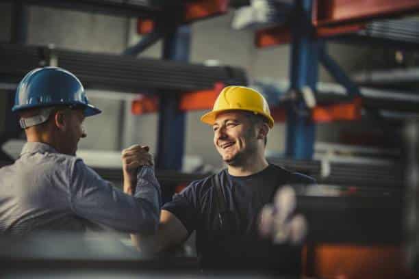Two workers handshake displaying good service and mutual respect and benefit. 